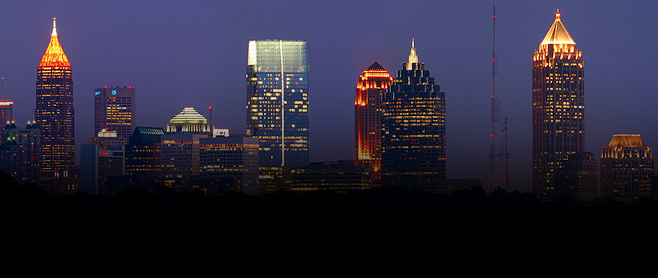 City skyline at night with illuminated buildings.